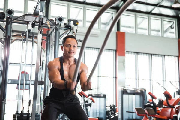 El hombre musculoso está haciendo ejercicio de cuerda de batalla —  Fotos de Stock