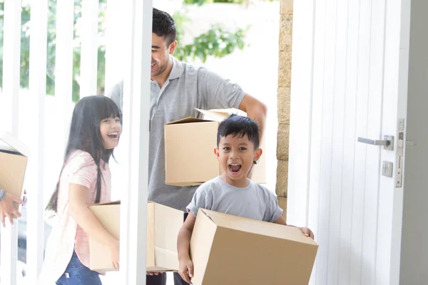 Padres e hijos con caja de cartón. mudanza a nueva casa — Foto de Stock