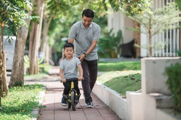 Dziecko z ojcem uczy się jeździć na rowerze — Zdjęcie stockowe