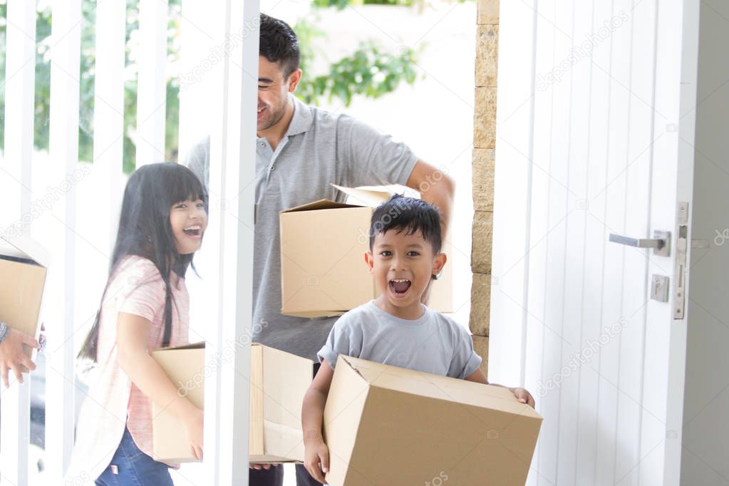 parent and kids with cardboard box. moving to new house