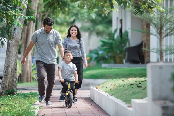 Bambini andare in bicicletta spinta da suo padre — Foto Stock