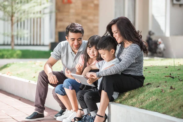 Familia joven moderna usando tableta — Foto de Stock