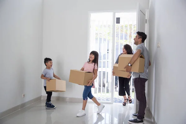 Padres e hijos con caja de cartón. mudanza a nueva casa — Foto de Stock