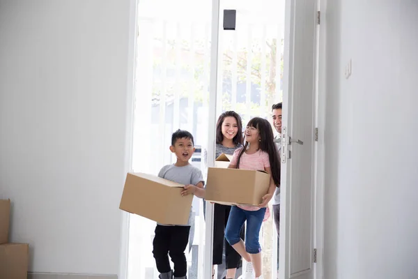 Padres e hijos con caja de cartón. mudanza a nueva casa — Foto de Stock