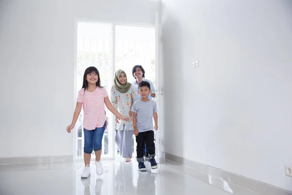 Gezin met twee kinderen voor het invoeren van hun nieuwe huis — Stockfoto