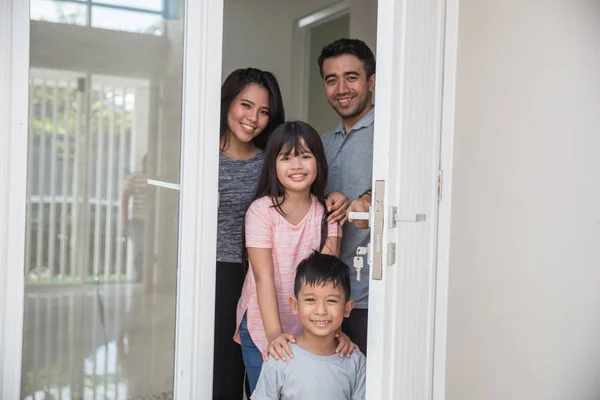 Happy family with kids open their house door — Stock Photo, Image