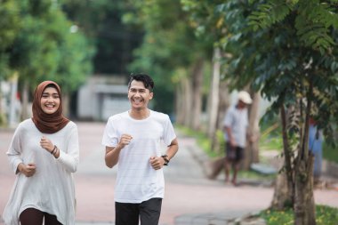 İki koşucu egzersiz üzerinde çalışıyor ve ısınmak