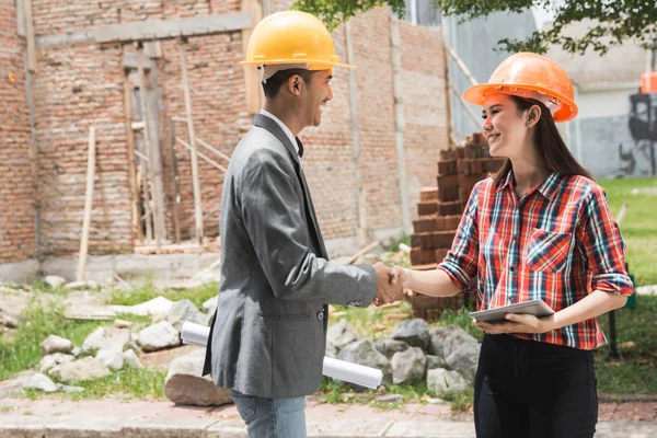 Diseñadores discutiendo plan de construcción estrechando la mano — Foto de Stock