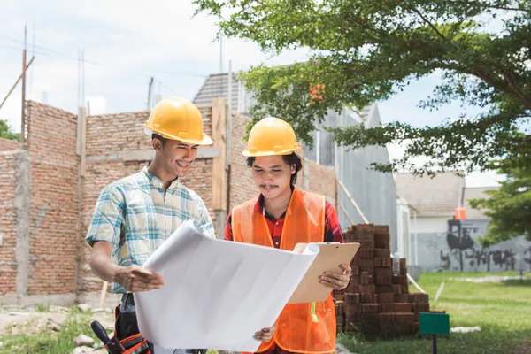 Dvě stavební dělník stojící před staveniště — Stock fotografie
