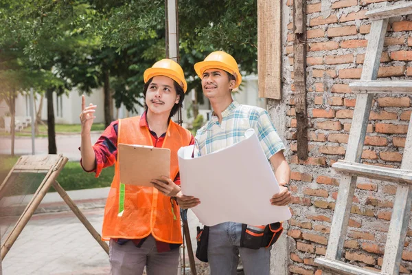 Två byggnadsarbetare står i byggplats — Stockfoto