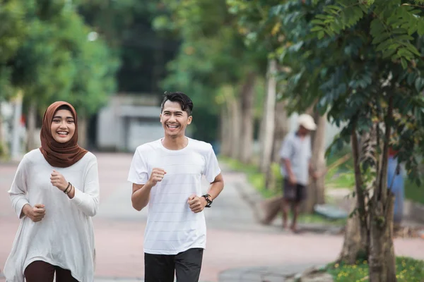 İki koşucu egzersiz üzerinde çalışıyor ve ısınmak