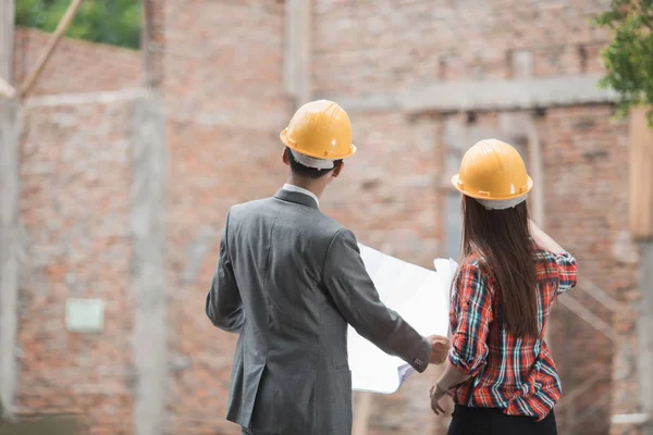 Diseñadores discutiendo plan de construcción — Foto de Stock