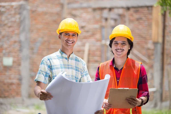 Dvě stavební dělník stojící před staveniště — Stock fotografie