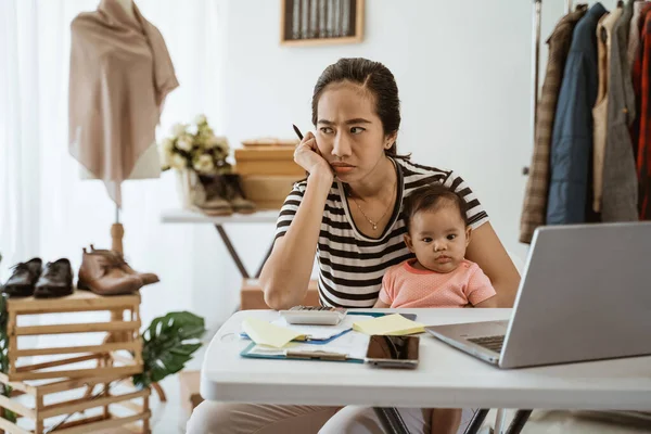 stress business owner carrying her baby while working