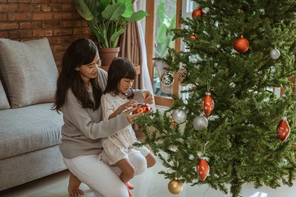 Gelukkig moeder en kind hangen enkele mooie accessoires — Stockfoto