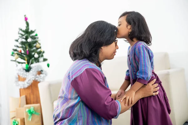 Mãe e filha abraçar e beijar uns aos outros no dia de Natal — Fotografia de Stock