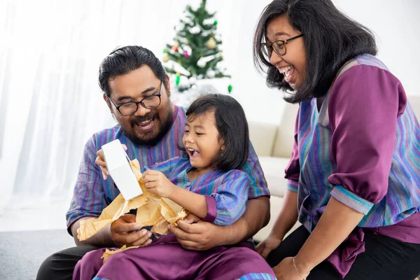 Kızı olan bir aile Noel hediyesini birlikte açar. — Stok fotoğraf