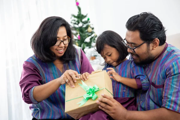 Сім'я з дочкою відкриває різдвяний подарунок разом — стокове фото