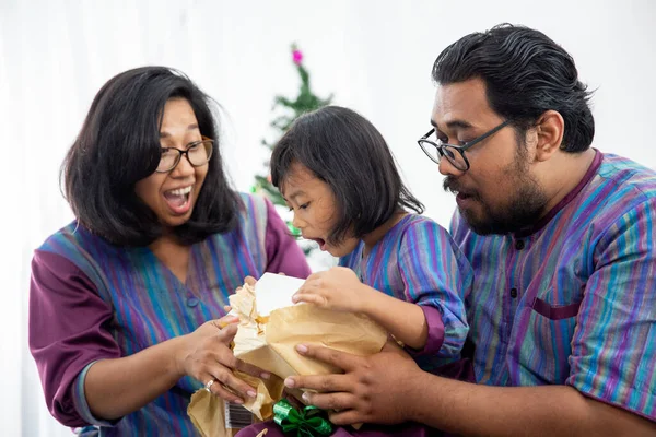 Family with daughter open christmas gift together — Stock Photo, Image