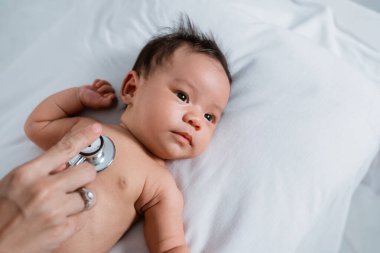 Doktor tarafından muayene edilirken küçük bebek