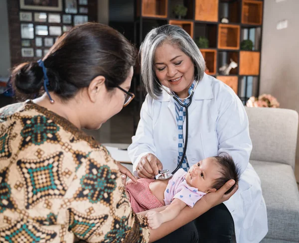 Médico examina um bebê pequeno — Fotografia de Stock