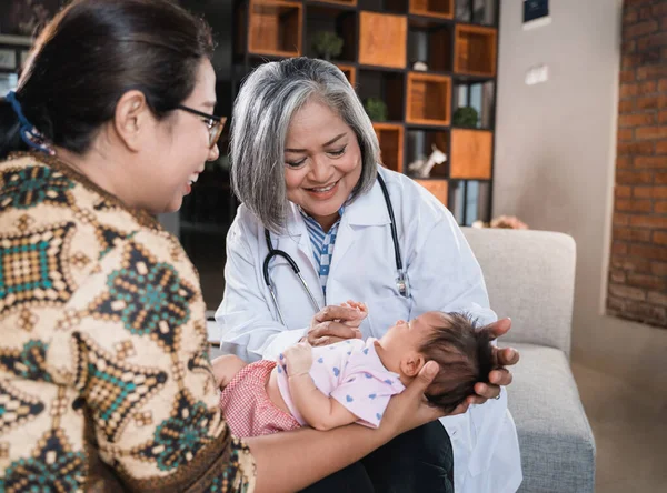 Médico examina um bebê pequeno — Fotografia de Stock