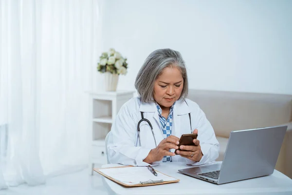 Senior kvinna läkare med hjälp av smartphone — Stockfoto