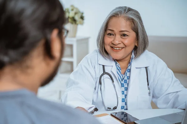 Artsen en patiënten praten en kijken elkaar aan — Stockfoto