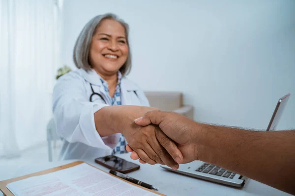 Doctor and patient shaking hands — Stock Photo, Image