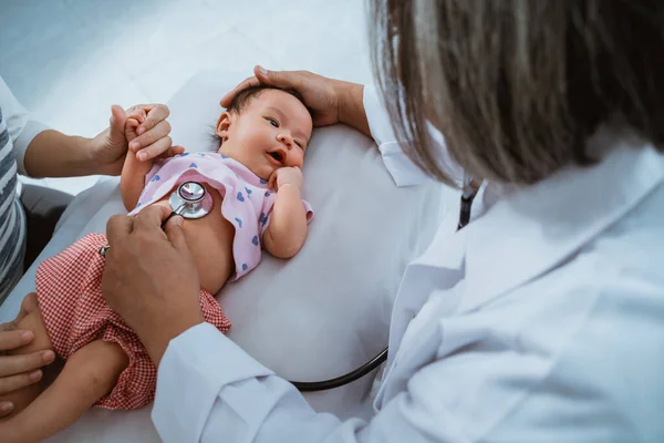 Pediatra médico examinando bebê menina — Fotografia de Stock