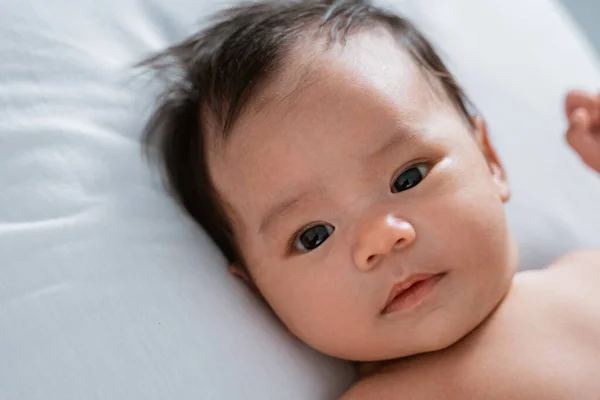 Niedliches Baby liegt auf weißem Kissen — Stockfoto