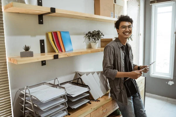 Confident business entrepreneur in his office smiling to camera — ストック写真