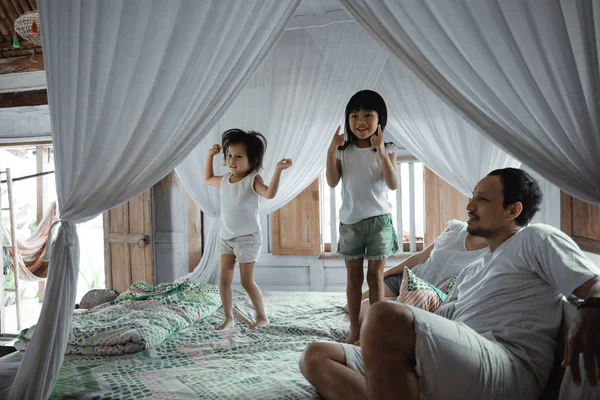 Щаслива сім'я грає разом на ліжку — стокове фото