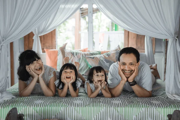 Азиатская счастливая семья и дочь, отдыхающая на кровати — стоковое фото