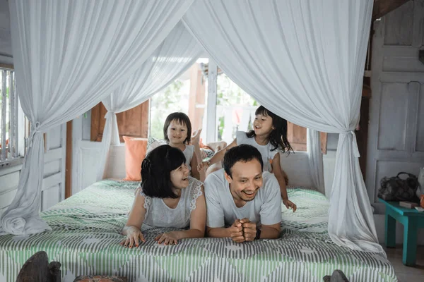 Keluarga bahagia Asia dan anak perempuan bersantai di tempat tidur — Stok Foto