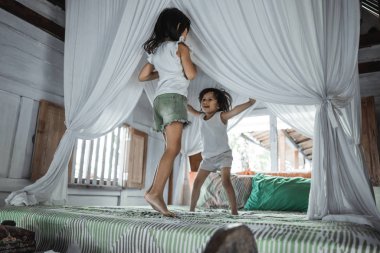 Yatakta zıplayan iki küçük kız