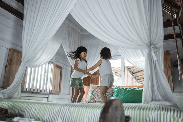 Two little girls jumping on bed — Stock Photo, Image