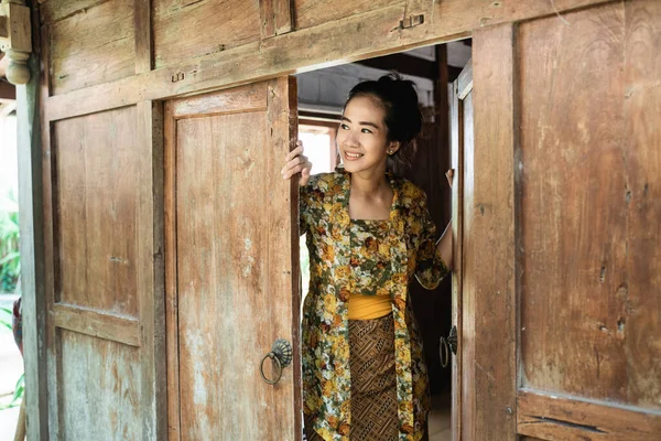 Asian young woman wearing a kebaya opens the door — 图库照片