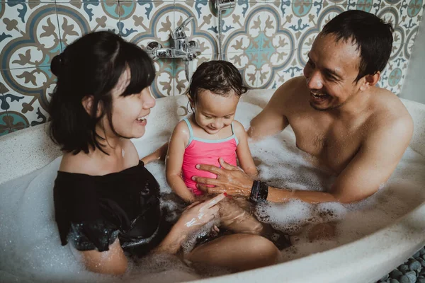 Heureuse famille asiatique tout en étant assis ensemble sur une baignoire — Photo