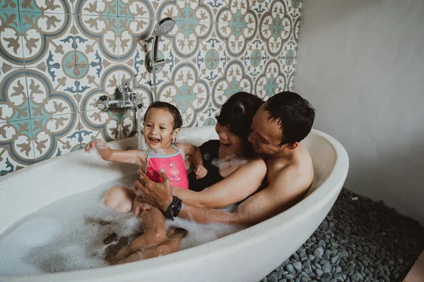 Família feliz com pequena filha na banheira — Fotografia de Stock