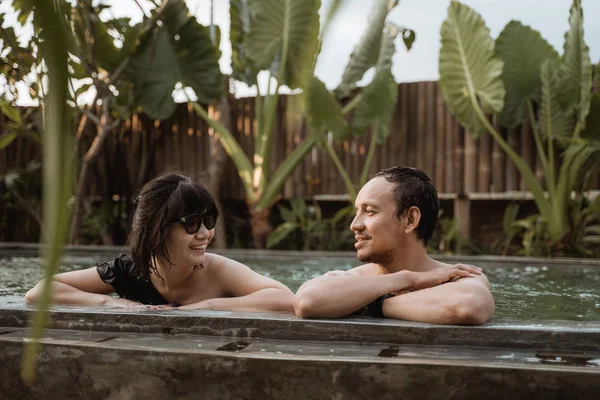 Ασιατικό ζευγάρι χαλαρώνει σε μια πισίνα — Φωτογραφία Αρχείου