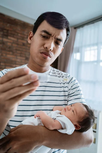 Asiático padre usando termómetro sentir preocupado acerca de su childrens salud —  Fotos de Stock