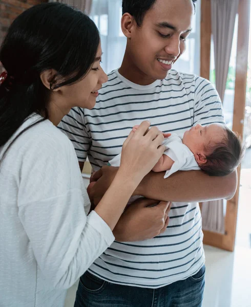 Vrolijke familie draagt kleine dochtertje — Stockfoto