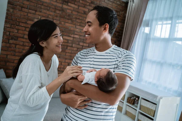 Alegre familia llevando pequeña hija bebé —  Fotos de Stock