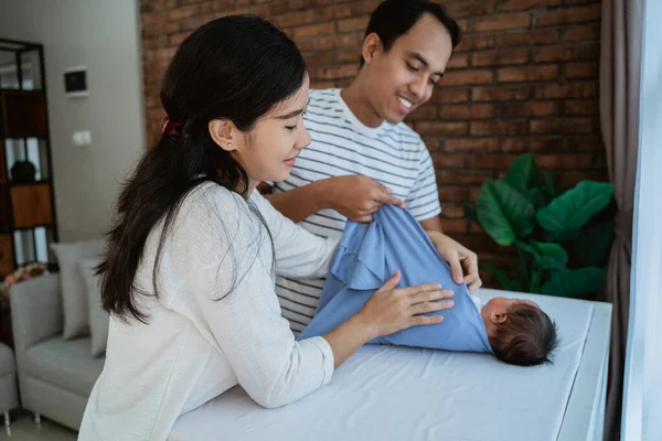 Gelukkig jong ouder verschonen luier kleine dochter samen — Stockfoto