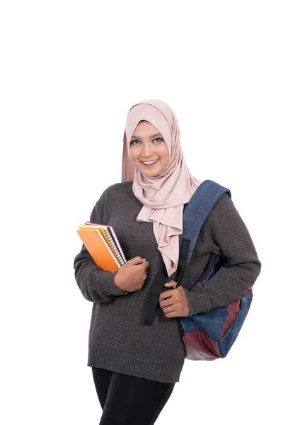 Estudiante velado llevando libros y bolsa con sonrisa mirando a la cámara —  Fotos de Stock