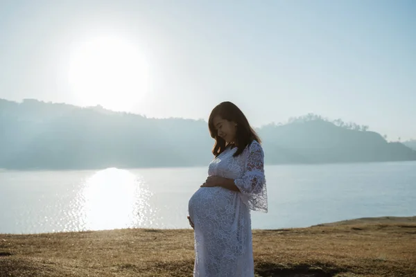 Asian mother pregnant having fun at sunrise — Stock Photo, Image