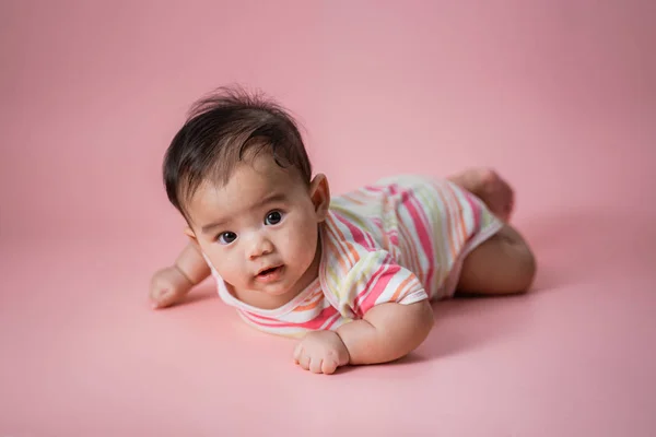 Baby laying on her belly in studio — Stock Photo, Image