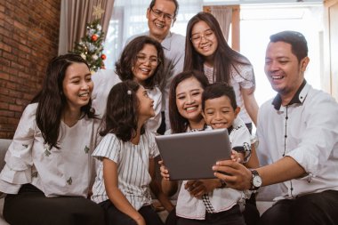 Asyalı aile Noel 'de tablet bilgisayar kullanıyor.