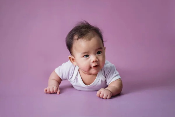 Bebé acostado sobre su vientre en el estudio —  Fotos de Stock